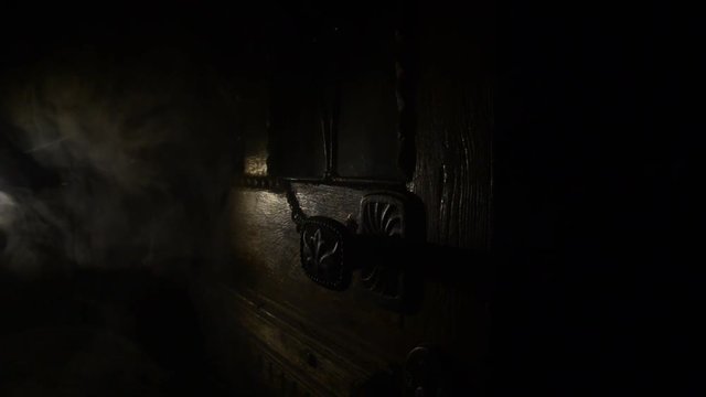 Close up view of old antique wooden door inside a dark room. Selective focus. Horror concept