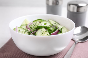 Delicious fresh cucumber onion salad in bowl served on table