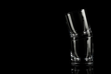 Empty whiskey glasses on black background. Space for text