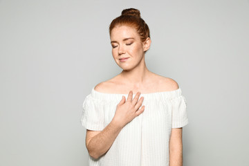 Portrait of young woman with beautiful face on grey background