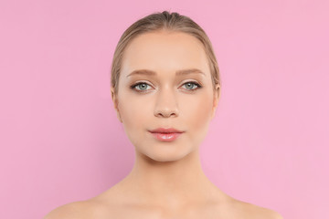 Portrait of young woman with beautiful face on pink background