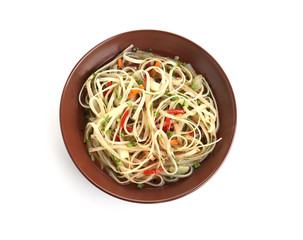 Plate of delicious noodles with broth and vegetables isolated on white, top view