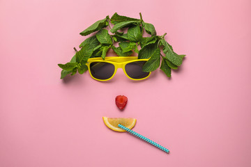 Funny face made of sunglasses, mint, strawberry, cocktail straw and citrus slice on color background, flat lay