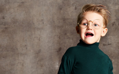 Portrait of a stylish little boy with glasses. Kid isolated on a light background. Success, idea, knowledge and study