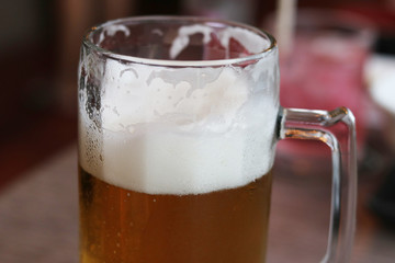 Glass of craft beer with bubble froth on a pub background. Concept drink alcohol for celebration, party, holiday , new year and festival .