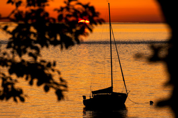 Sailboat Anchored Off an Island During Sunset. Anchored off of Lummi Island in the Puget Sound area...
