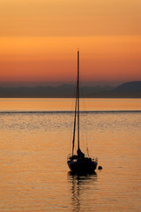 Sailboat Anchored Off an Island During Sunset. Anchored off of Lummi Island in the Puget Sound area...