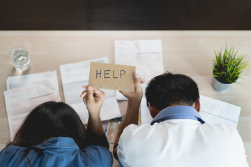 Top view of stressed young asian woman trying to find money to pay credit card debt. Selective focus on hand.