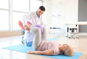 Obraz premium Physiotherapist working with mature patient in rehabilitation center