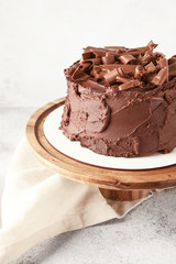 Stand with tasty chocolate cake on table