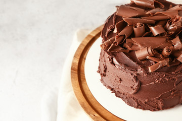 Stand with tasty chocolate cake on table