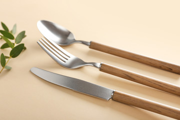 Silver cutlery on color background