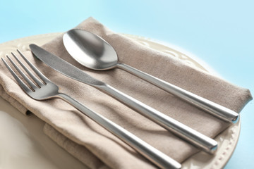 Plate with cutlery on color background, closeup