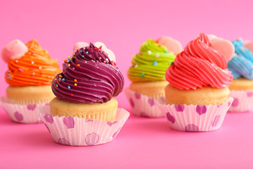 Sweet tasty cupcakes on color background