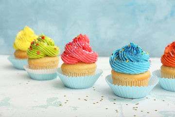 Sweet tasty cupcakes on light table