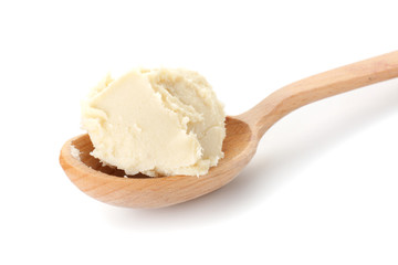 Spoon with shea butter on white background