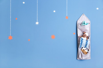 Hanging fabric organizer with child toys on color background