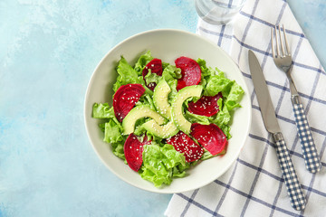 Bowl with tasty beet salad on color background