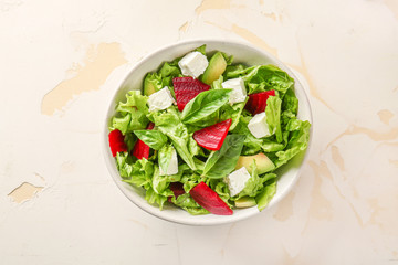 Bowl with tasty beet salad on light background