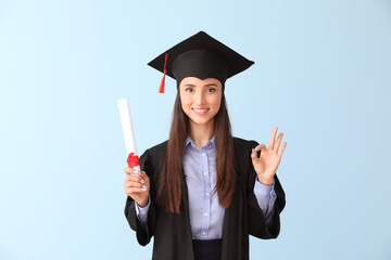 Female graduate with diploma showing OK on color background
