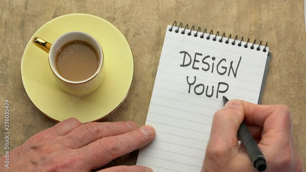 Canvas Prints design your life - a man hand writing a note with a black marker in a spiral notebook, overhead view