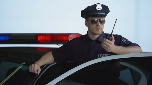 Officer Getting Out From Car And Informing Station About Crime On Two-way Radio