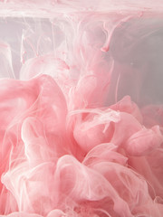 Acrylfarben und Tusche in Wasser. Abstrakter Hintergrund, Wolke aus seidiger Tinte im Wasser auf weißem, isoliertem Hintergrund, Tintentropfen im Wasser, rosa Tintenspritzer