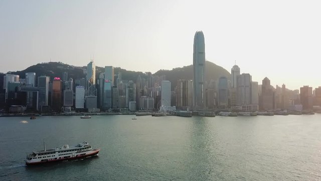 Aerial: Ferry on Victoria Harbor and Iconic Hong Kong Skyline Behind
