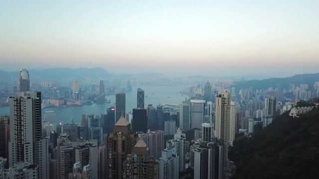 Aerial: Panning Above the City and Harbor of Hong Kong with Many Skyscrapers