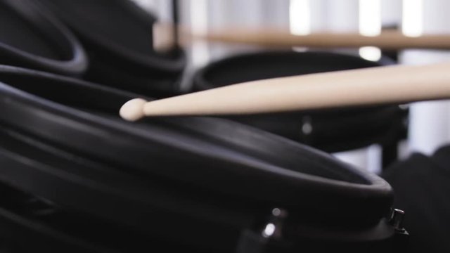 Close up of drum sticks bouncing off an electric drum in slow motion