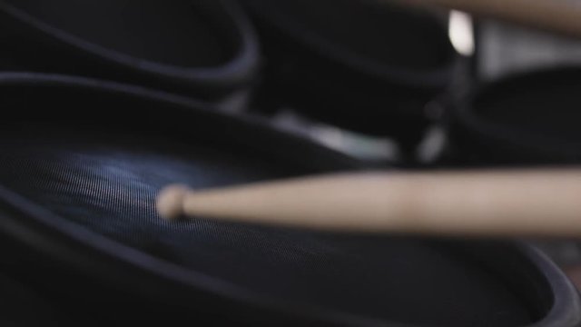 Close up of drum sticks hitting an electric drum in slow motion