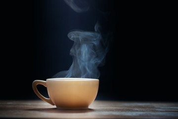 Cup of coffee with steam on black background