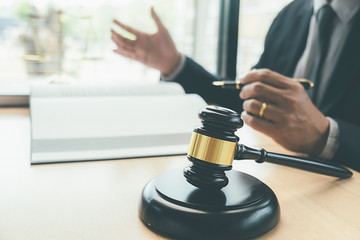 Judge gavel with Justice lawyers having team meeting at law firm background. Concepts of Law and Legal services.