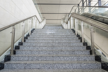 Perspective of clean marble steps and glass steel handrails in the building hall now