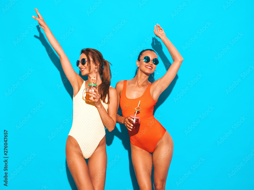 Wall mural two beautiful sexy smiling hipster women in summer colorful swimwear bathing suits.trendy girls in s