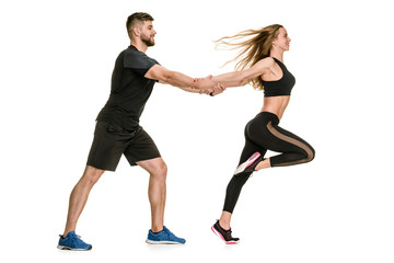Obraz na płótnie Canvas Side view of happy athletic couple training on white background