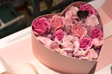 Obraz na płótnie Canvas flower box in the shape of heart with pink rose flowers