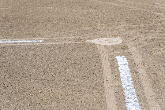 Close up of freshly chalked baseline leading to home plate, dirt only, empty baseball field on a sunny day
