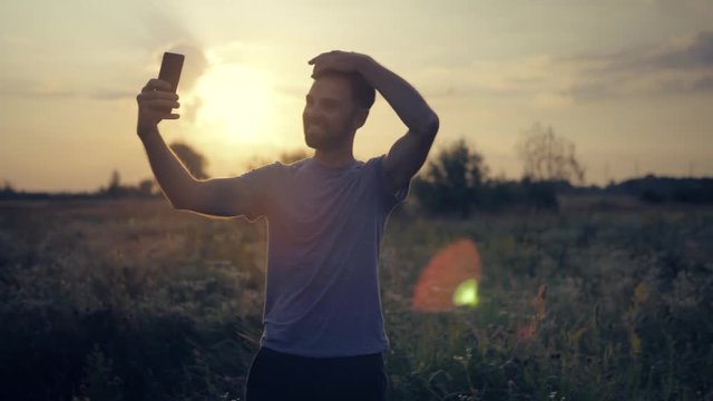 Taking Selfie Photo At Sunset.Man Taking Selfie At Sunrise.Happy Man Taking Selfie By Mobile Phone.Male Self Photo With Mobile Phone.Male Self Phtotographing. Photographing At Sunset.Male Makes Photos