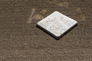 Close up of baseball base plate on a freshly groomed dirt field