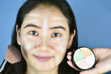 Asian woman applying cosmetics makeup foundation and using color correction concealer, Learning doing self makeup.