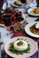 A gourmet dinner for two: grilled camembert, red wine and various appetizers.