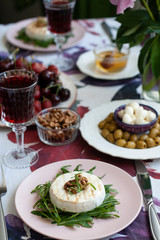 A gourmet dinner for two: grilled camembert, red wine and various appetizers.