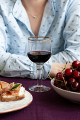 A gourmet break: a glass of wine, cherries and baguette slices with pastrami.