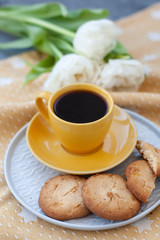 A tasty treat: a cup of coffee and a plate of cookies.