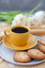 A tasty treat: a cup of coffee and a plate of cookies.