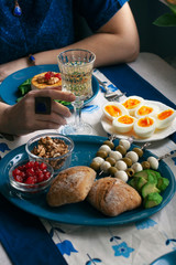 A gourmet dinner: grilled camembert, a glass of wine and various appetizers.