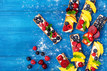 Low calorie summer sandwiches with creamy cheese and berry fruits top view. Easy snack for breakfast or lunch.