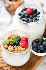 Jar of yogurt topped with granola and berries. Concept of clean eating, healthy lifestyle, dieting, weight loss