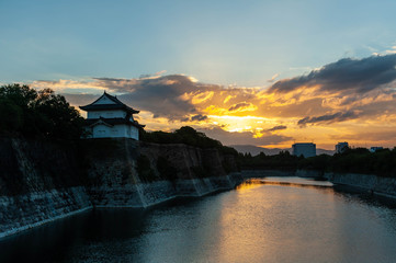 夜明けの大阪城の堀とオレンジ色の雲